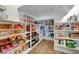 Well-organized pantry featuring wooden baskets and multiple shelves stocked with groceries and household essentials at 9007 Antora Summit St, Las Vegas, NV 89166