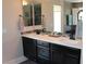 Bathroom vanity with dual sinks, black cabinets, and a decorative backsplash at 945 Pomander Point Pl, Henderson, NV 89012