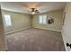 This bedroom features neutral walls, carpet, ceiling fan, and an abundance of natural light from two windows at 945 Pomander Point Pl, Henderson, NV 89012