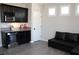 Entertaining space featuring dark cabinetry, granite countertops, a beverage fridge, and a comfortable sofa at 945 Pomander Point Pl, Henderson, NV 89012