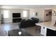 Open-concept living room featuring wood-look tile, plush sofa, entertainment center, and lots of light at 945 Pomander Point Pl, Henderson, NV 89012