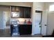 Wet bar features dark cabinetry, granite countertops, a beverage fridge, and a stacked washer and dryer at 945 Pomander Point Pl, Henderson, NV 89012