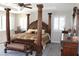 A main bedroom includes a four poster bed, carpet and natural light from windows at 945 Pomander Point Pl, Henderson, NV 89012