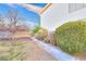 Landscaped backyard featuring a stone pathway, mature trees, and diverse shrubs offering a private oasis at 9879 Jazzy June St, Las Vegas, NV 89183