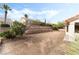 View of the backyard featuring tiered retaining walls, desert landscaping and access to the home at 10029 Netherton Dr, Las Vegas, NV 89134