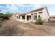 Backyard view of single-story home with desert landscaping, a covered patio and large windows at 10029 Netherton Dr, Las Vegas, NV 89134