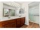 Bathroom features a double sink vanity, a large mirror, and a walk-in shower with a sliding glass door at 10029 Netherton Dr, Las Vegas, NV 89134