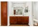 Bathroom with a double sink vanity, wood cabinets, large mirror and a toilet in a separate nook at 10029 Netherton Dr, Las Vegas, NV 89134