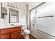 Well-maintained bathroom featuring wood vanity, framed mirror, and a shower-tub combination with glass door at 10029 Netherton Dr, Las Vegas, NV 89134