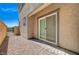 Backyard patio features stone ground cover and a sliding glass door leading to an outdoor living space at 10699 Sariah Skye Ave, Las Vegas, NV 89166