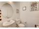 Modern powder room featuring pedestal sink, round mirror, and stylish art at 10699 Sariah Skye Ave, Las Vegas, NV 89166