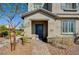 Inviting front entrance featuring a covered porch, blue front door, brick walkway, and xeriscaped landscaping at 10699 Sariah Skye Ave, Las Vegas, NV 89166