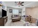 Bright living room with neutral decor, wood-look tile flooring, ceiling fan, and plenty of natural light at 10699 Sariah Skye Ave, Las Vegas, NV 89166