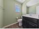 Powder room featuring wood-look flooring, green walls, and a black vanity with white countertops at 120 Campbelltown Ave, Henderson, NV 89015