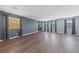 Bright living room featuring hardwood floors, grey walls, multiple windows with shades and decorative curtains at 120 Campbelltown Ave, Henderson, NV 89015