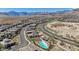 Panoramic aerial of a vibrant community with a pool, construction and scenic mountain views at 12422 Tudor Arch Dr, Las Vegas, NV 89138