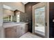 Modern bathroom features a large mirror, wooden cabinets, and a glass door to the outside at 12422 Tudor Arch Dr, Las Vegas, NV 89138