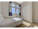 Bright bedroom features a large window with decorative curtains and wood-look flooring at 12422 Tudor Arch Dr, Las Vegas, NV 89138