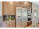 Gourmet kitchen with stainless steel refrigerator, and plentiful wood cabinetry at 12422 Tudor Arch Dr, Las Vegas, NV 89138