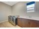 Well-equipped laundry room with front-loading machines, sink, and ample counter space at 12422 Tudor Arch Dr, Las Vegas, NV 89138