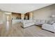 Open-concept living area featuring wood-look tile floors and a large sectional couch at 12422 Tudor Arch Dr, Las Vegas, NV 89138