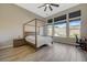 Spacious main bedroom with a four-poster bed, ceiling fan, and large windows at 12422 Tudor Arch Dr, Las Vegas, NV 89138