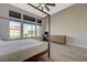 Bright main bedroom with a four-poster bed, modern design and an exterior view at 12422 Tudor Arch Dr, Las Vegas, NV 89138