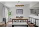 Bright dining area featuring a wooden table with bench seating, modern light fixture, and abstract art, flowing seamlessly into the kitchen at 1800 Edmond St # 215, Las Vegas, NV 89146