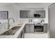 Well-lit kitchen featuring stainless steel appliances, gray cabinets, modern hardware, white countertops, and a stylish backsplash at 1800 Edmond St # 215, Las Vegas, NV 89146