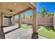 The covered back patio features a ceiling fan, brick pillars, and stone pavers with artificial turf at 183 Baru Belin Ave, Las Vegas, NV 89183