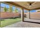 The backyard has a covered patio with a ceiling fan overlooking the artificial turf at 183 Baru Belin Ave, Las Vegas, NV 89183