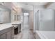 Bathroom featuring a glass shower, soaking tub, dual vanities, and wood-look flooring at 183 Baru Belin Ave, Las Vegas, NV 89183