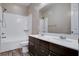 Bright bathroom featuring a shower-tub combo, double sink vanity with white countertop, and wood-look floors at 183 Baru Belin Ave, Las Vegas, NV 89183