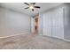 Carpeted bedroom with closet, ceiling fan, and natural light provides a serene retreat at 183 Baru Belin Ave, Las Vegas, NV 89183