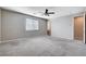 Bright, carpeted bedroom with a ceiling fan, window with blinds, and an ensuite bathroom entrance at 183 Baru Belin Ave, Las Vegas, NV 89183