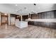 Modern kitchen featuring dark wood cabinets, granite countertops, and a center island with pendant lighting at 183 Baru Belin Ave, Las Vegas, NV 89183