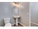 Stylish half bathroom with a pedestal sink, oval mirror, and wood-look flooring at 183 Baru Belin Ave, Las Vegas, NV 89183