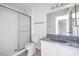 Bathroom featuring a glass-enclosed shower, vanity with grey countertop, and a toilet, showcasing modern functionality at 211 N Lamb Blvd # C, Las Vegas, NV 89110