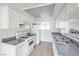 Well-lit kitchen with white cabinetry, gray countertops, tile flooring, and stainless steel sink at 211 N Lamb Blvd # C, Las Vegas, NV 89110