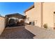 Gravel backyard with a covered carport providing parking or storage, alongside a home's exterior at 2111 River City Dr, Laughlin, NV 89029