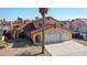 Exterior of a stucco home with an attached three-car garage and desert landscaping at 2111 River City Dr, Laughlin, NV 89029