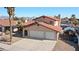 Exterior of a stucco home with an attached three-car garage and desert landscaping at 2111 River City Dr, Laughlin, NV 89029