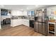 Well-lit kitchen featuring white cabinets, stainless steel appliances, and wood-style floors at 2111 River City Dr, Laughlin, NV 89029