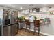 Stylish kitchen featuring a breakfast bar, stainless steel refrigerator, and white cabinetry at 2111 River City Dr, Laughlin, NV 89029