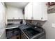 Functional laundry room with gray machines and white storage cabinets at 2111 River City Dr, Laughlin, NV 89029