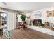 Cozy living room featuring a stone fireplace, wood floors and access to the backyard at 2111 River City Dr, Laughlin, NV 89029