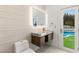 Bright bathroom featuring a modern vanity and a door leading to the pool area at 2293 Buckingham Ct, Henderson, NV 89074