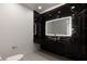 Stylish bathroom with a black marble accent wall and modern illuminated mirror at 2293 Buckingham Ct, Henderson, NV 89074