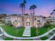 Stunning two-story home with manicured lawn, palm trees, and modern walkway leading to the front door at 2293 Buckingham Ct, Henderson, NV 89074