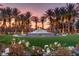 Beautiful fountain surrounded by palm trees, lush landscaping, and blooming flowers at 2293 Buckingham Ct, Henderson, NV 89074